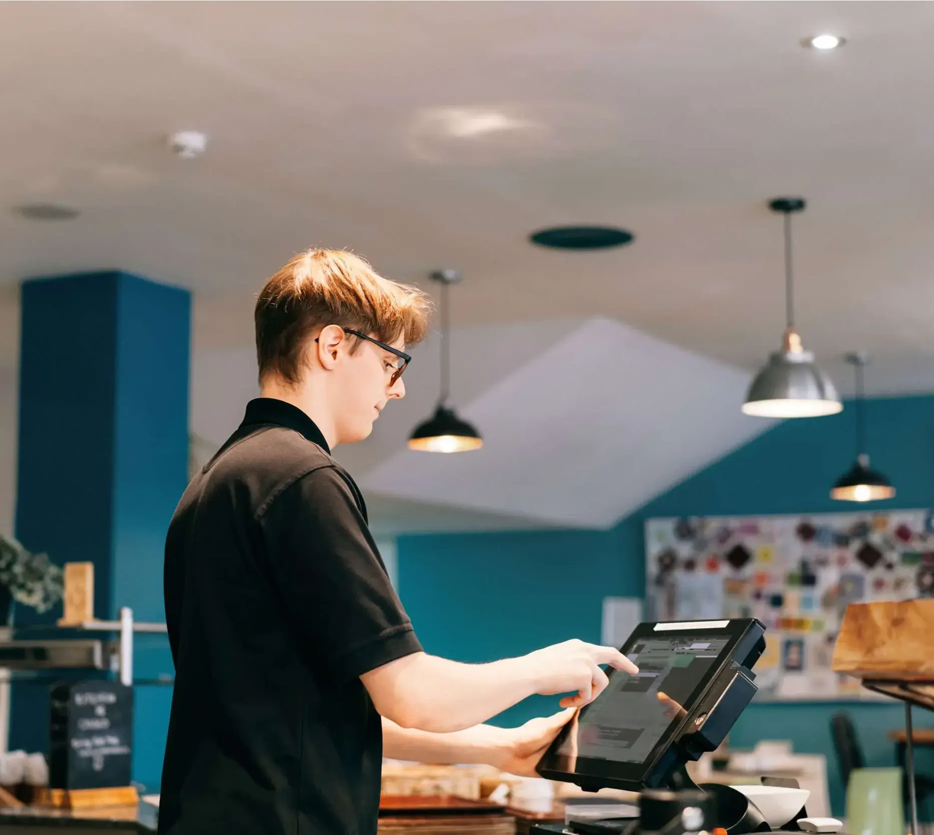 Male hospitality employee using a POS system to process orders and manage transactions.