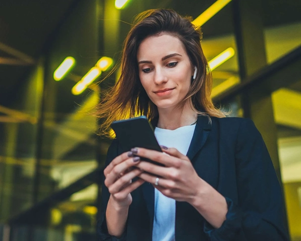 Female hospitality worker reviewing schedules and updates through Rota King hospitality rostering software on her phone